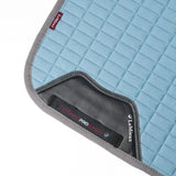 Light blue quilted lemieux self-cool dressage square with gray trim and black leather accent for riding comfort