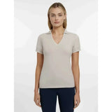 A soft light beige lemieux serena sports polo stone with short sleeves subtle v-neck and folded collar