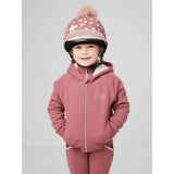 A child wearing a pink star-patterned helmet and lemieux sherpa lined lily hoodie orchid with fluffy pom-pom on top