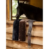 Lemieux simuwool faux lambswool girth cover black and dark gray saddles with faux fur lining on wooden ledge
