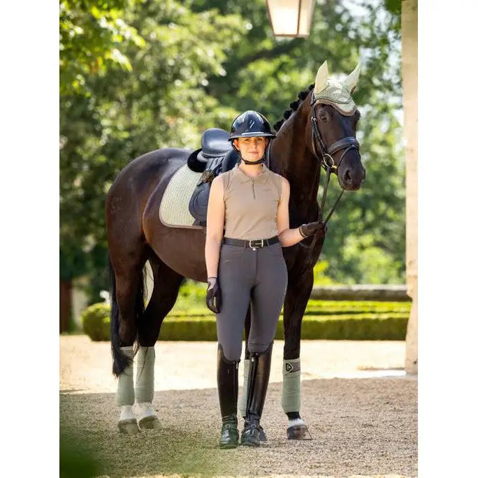 Rider in Lemieux Sleeveless Sport Polo Mink next to a saddled brown horse