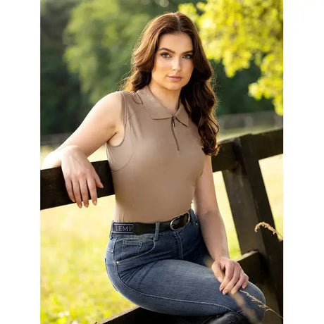 Woman in Lemieux Sleeveless Sport Polo Mink on a fence, showcasing super lightweight fabric