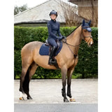 A rider in navy blue gear on a chestnut horse wearing lemieux soft shell anti slip eurojump square navy saddle pad