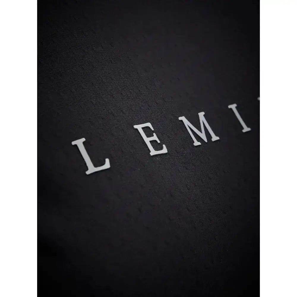 White embossed lemi letters on textured black fabric of lemieux sports t-shirt with sweat-wicking fabric