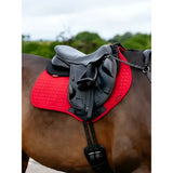 Red quilted lemieux suede close contact square chilli saddle pad with black leather straps under gray horse saddle