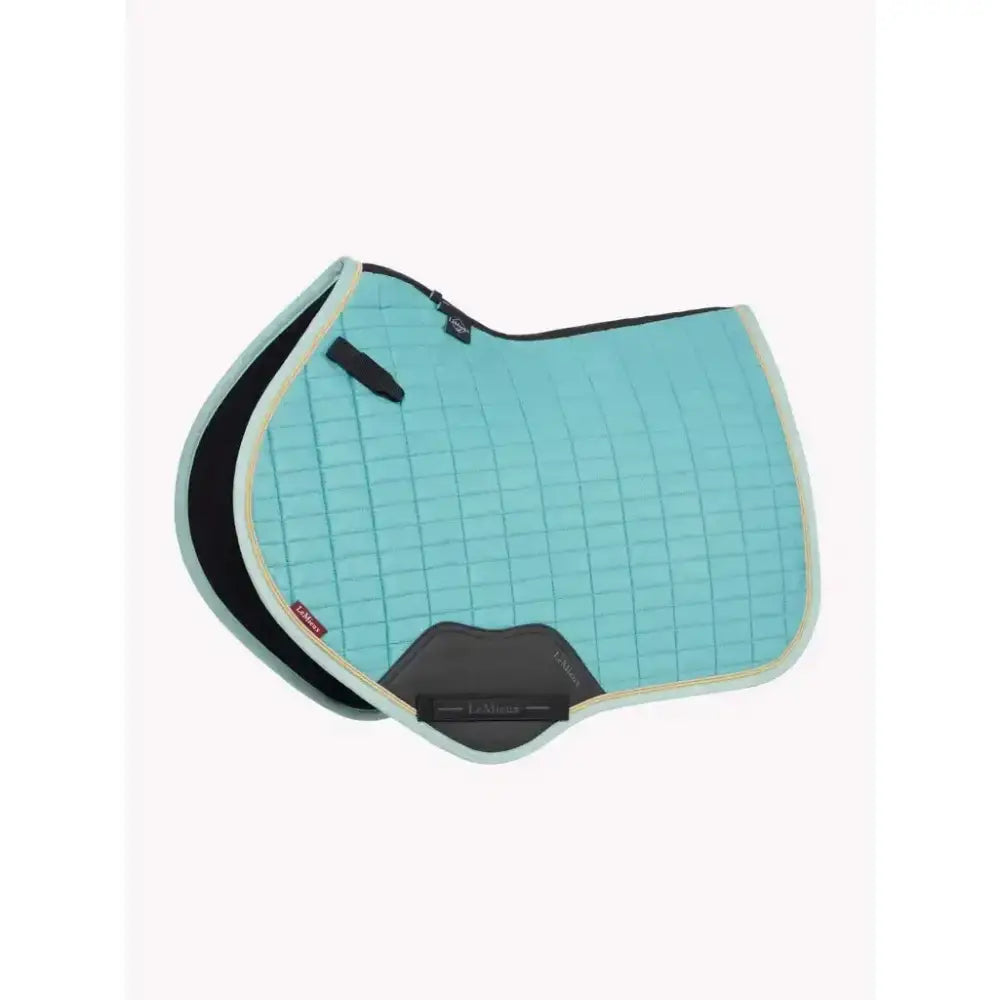 A light blue quilted lemieux suede close contact square lagoon saddle pad with black gray trim and padded design for comfort