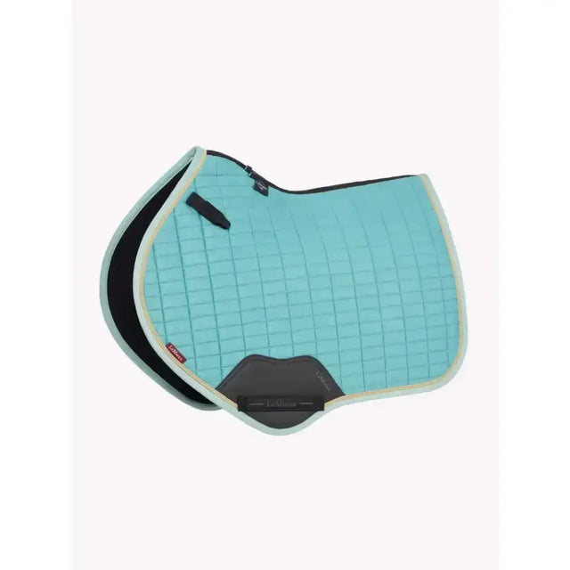 A light blue quilted lemieux suede close contact square lagoon saddle pad with black gray trim and padded design for comfort
