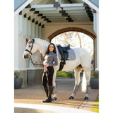 A white horse wearing lemieux suede dressage square grey with soft suede binding and gray leg wraps