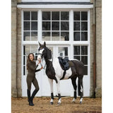 A sleek black-and-white pinto horse wearing a lemieux suede gp square with high wither cut and elasticated d-ring tabs