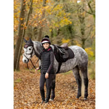 A dapple grey horse in autumn forest wearing a lemieux suede classic general purpose suede gp square saddle pad cinder