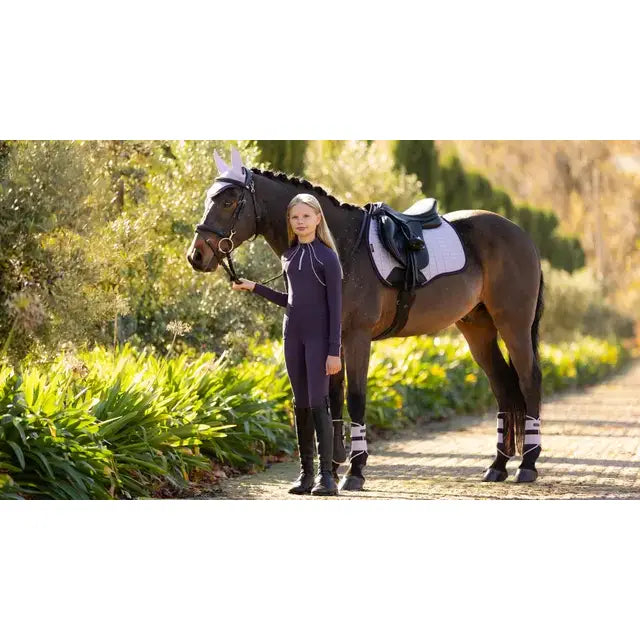 Dark brown horse wearing a lemieux suede gp square lilac saddle pad with black bridle for riding use