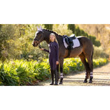 Dark brown horse wearing a lemieux suede gp square lilac saddle pad with black bridle for riding use
