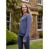 A woman wearing a lemieux tabi tech hoodie dusk blue with long sleeves and a front pocket featuring a tech zip