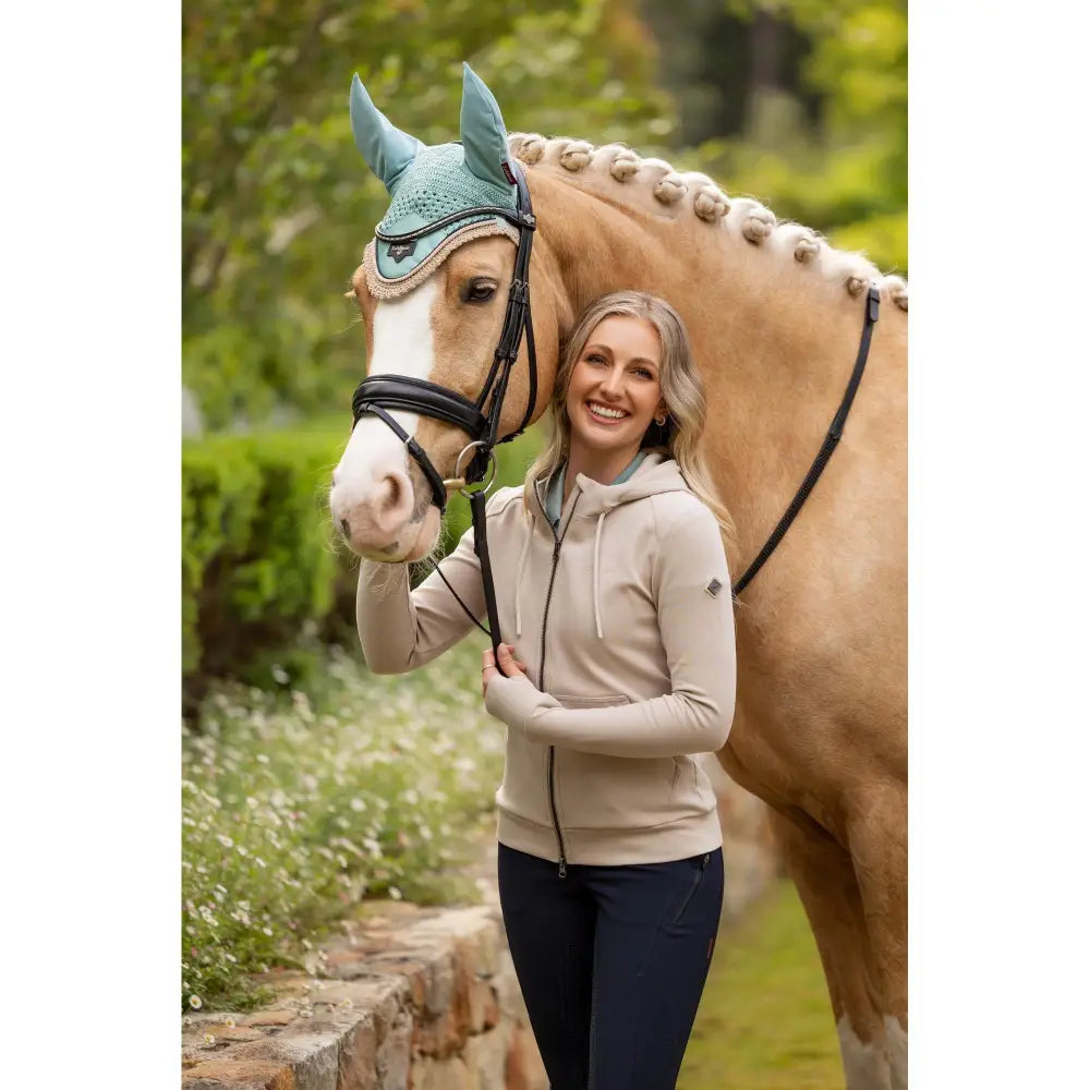 Teal crocheted horse hood with ear flaps and trim paired with lemieux tabi tech zip hoodie stone for riding comfort