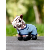 A lemieux tiny pony plush horse with white and brown spots wearing a light blue fleece tiny pony montana blanket