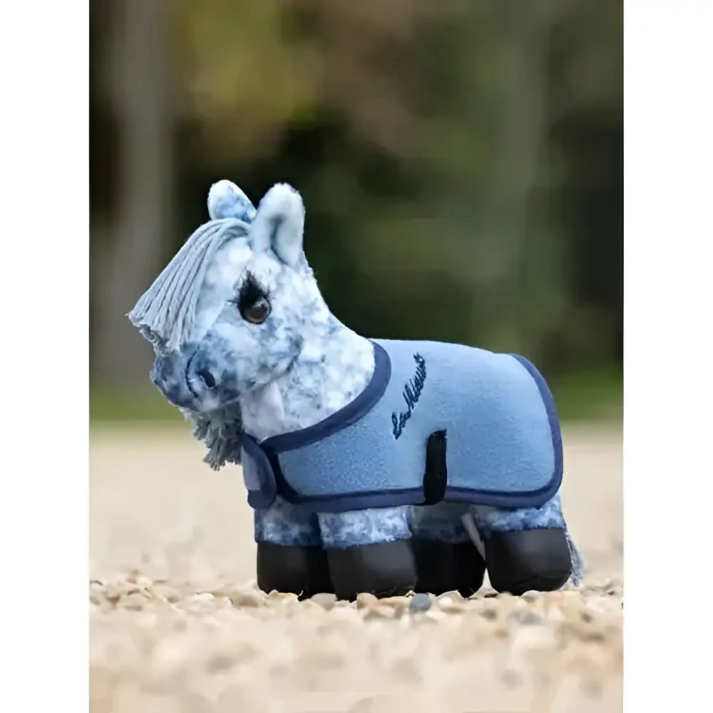 A plush lemieux tiny pony sammy figurine with a light blue textured blanket and dark blue trim showing the back side