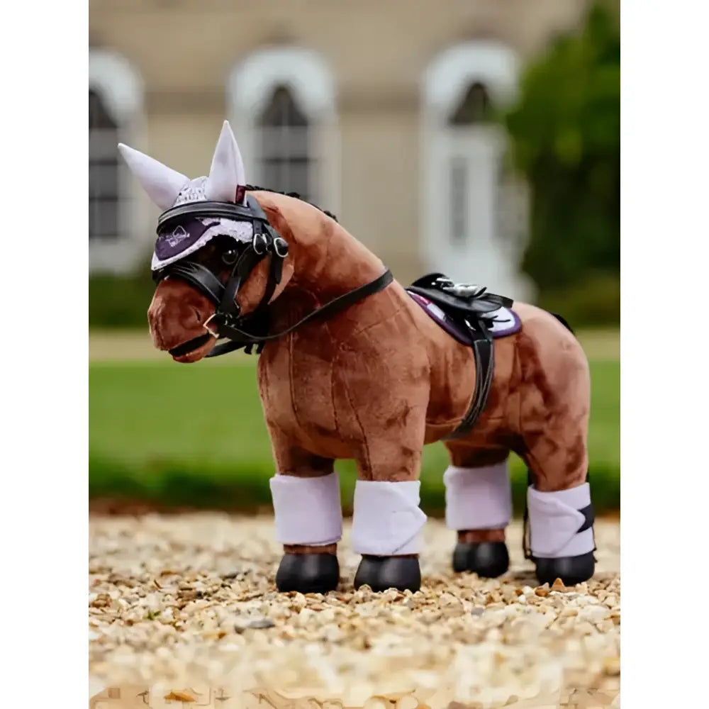Brown plush lemieux toy pony wearing black and white equestrian gear with lilac pony bandages lilac wraps
