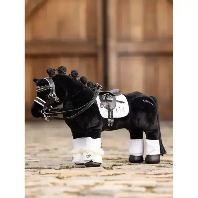 Black lemieux toy pony with white reach boot dressage leg wraps and braided mane detailed saddle and bridle