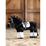 Black lemieux toy pony with white reach boot dressage leg wraps and braided mane detailed saddle and bridle