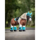 A plush brown and white lemieux toy pony wearing turquoise pony fly hood azure with bridle saddle pad leg wraps and hoof covers