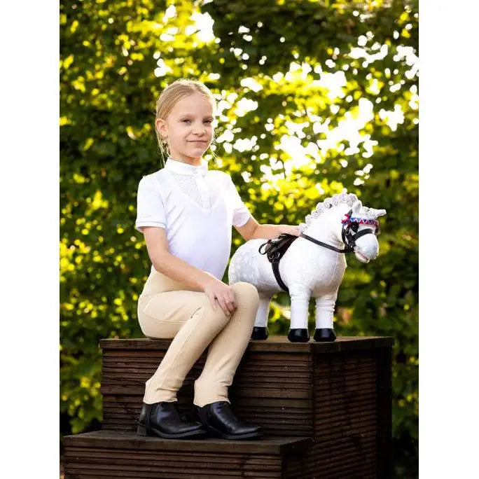 Young child on wooden steps with Lemieux Toy Pony Coco in playful setting