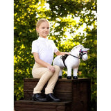 Young child on wooden steps with Lemieux Toy Pony Coco in playful setting