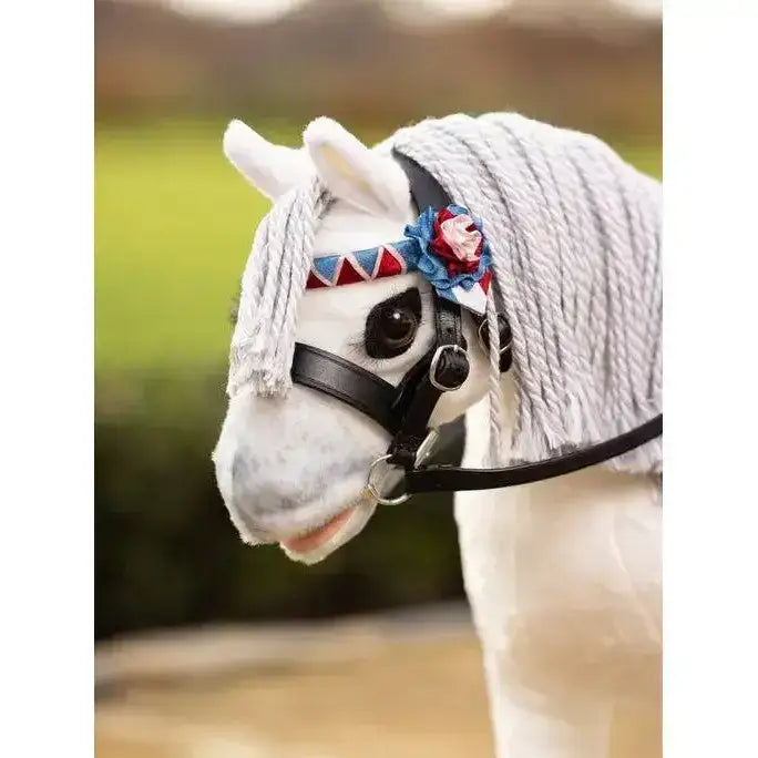 White plush lemieux toy pony wearing a black leather pony showing bridle with red white and blue braided headpiece