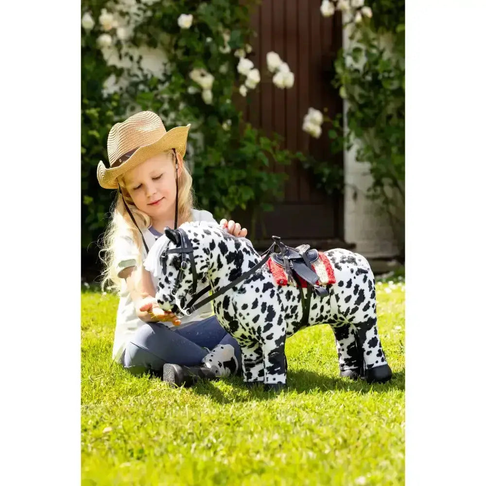 A plush lemieux toy pony western rocking horse with dalmatian black spots and a red and black western pad chilli saddle