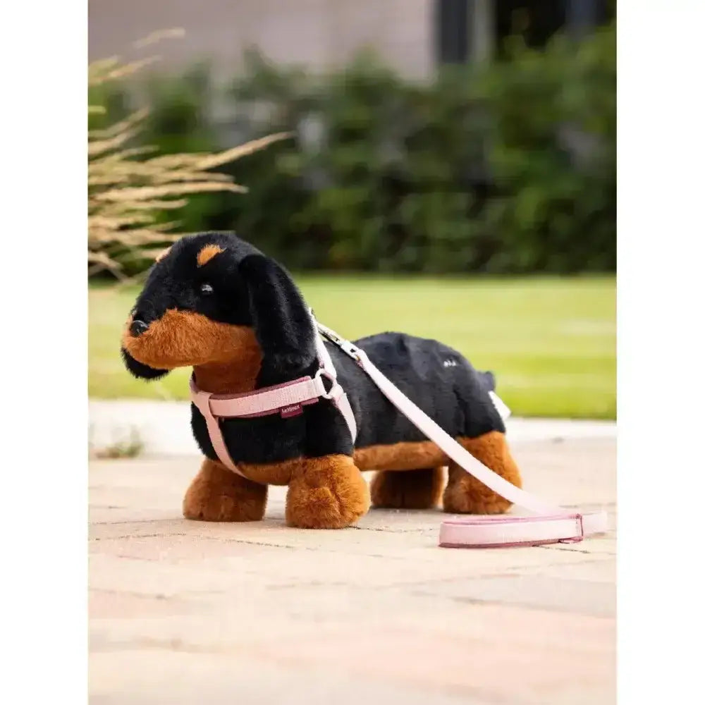 A plush black and tan dachshund lemieux toy puppy sally with a pink harness and leash for kids and collectors