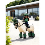 A toy rider maya doll in a green outfit rides a cream horse figurine with dark green wraps lemieux toy rider