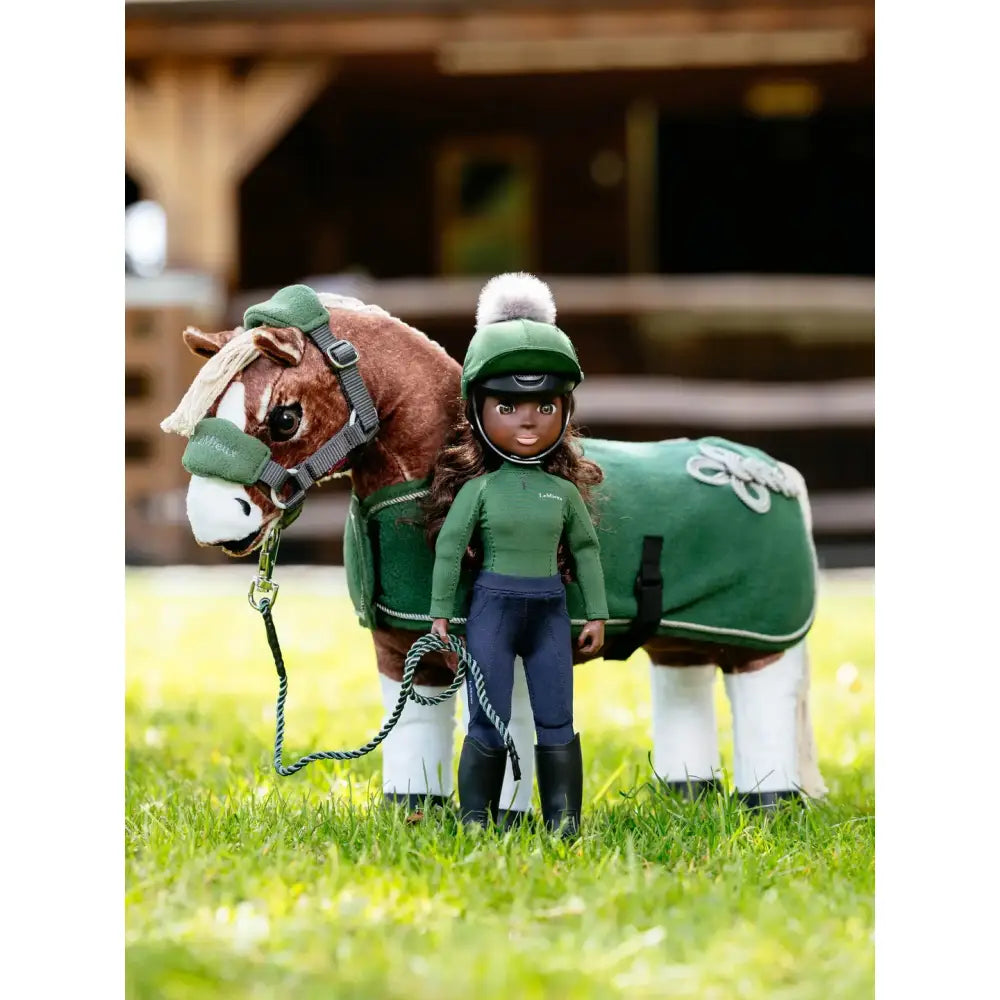 A plush brown horse with a white mane and face wearing a green blanket and bridle lemieux toy rider maya