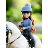 A lemieux toy rider olivia doll wearing a blue riding helmet with gray pom pom and matching outfit for toy pony play