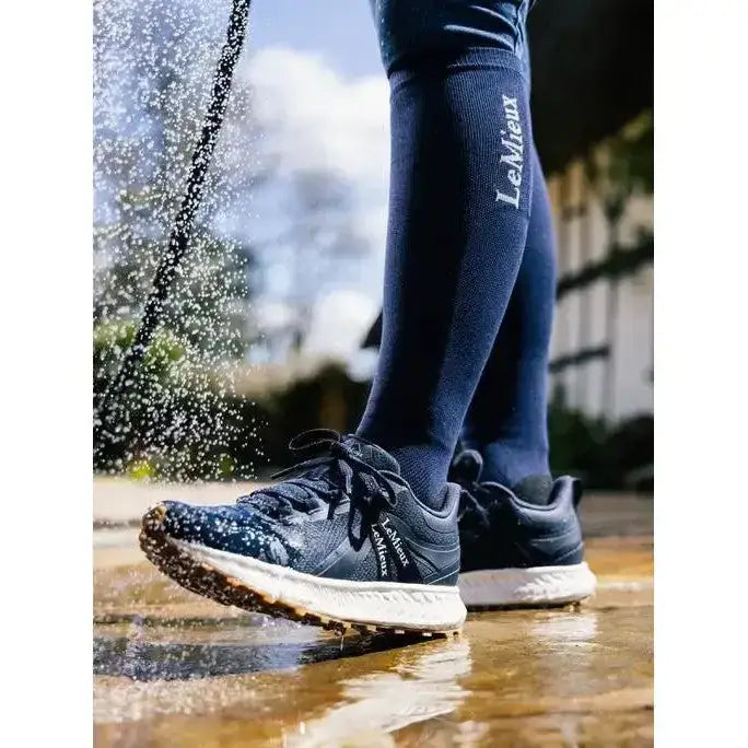 Dark blue lemieux trax waterproof all-terrain trainer with speckled upper and white midsole worn with matching compression socks