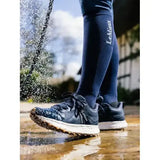 Dark blue lemieux trax waterproof all-terrain trainer with speckled upper and white midsole worn with matching compression socks