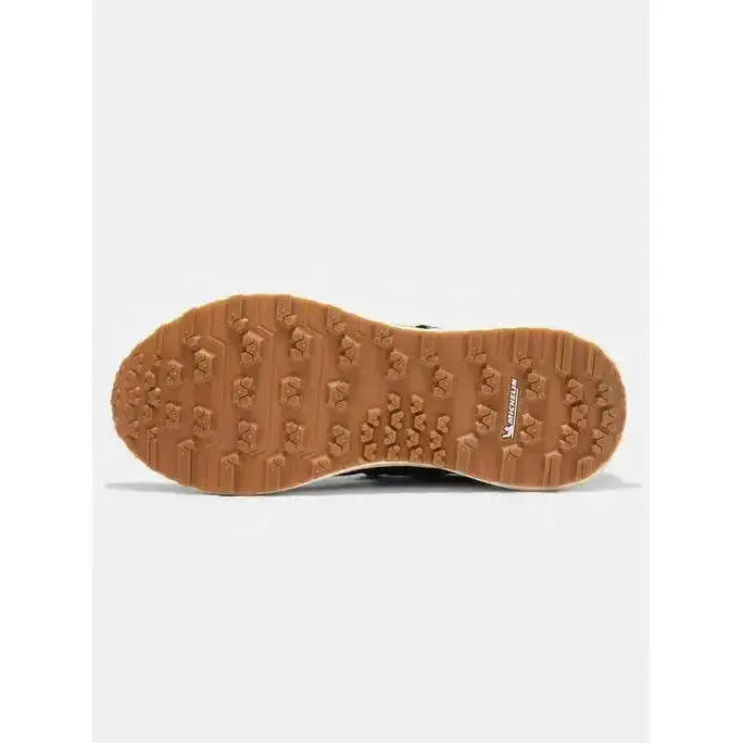 Tan rubber sole with chunky tread and michelin logo on the side of lemieux trax waterproof trainer navy