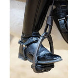 Black metal close contact stirrup with adjustable strap and buckle attached to a black leather boot lemieux vector close