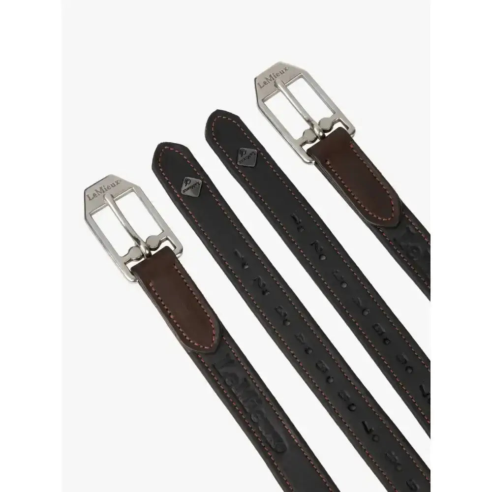 Three dark brown lemieux vector stirrup leather belts with silver buckles and brown stitching showcasing embossed patterns