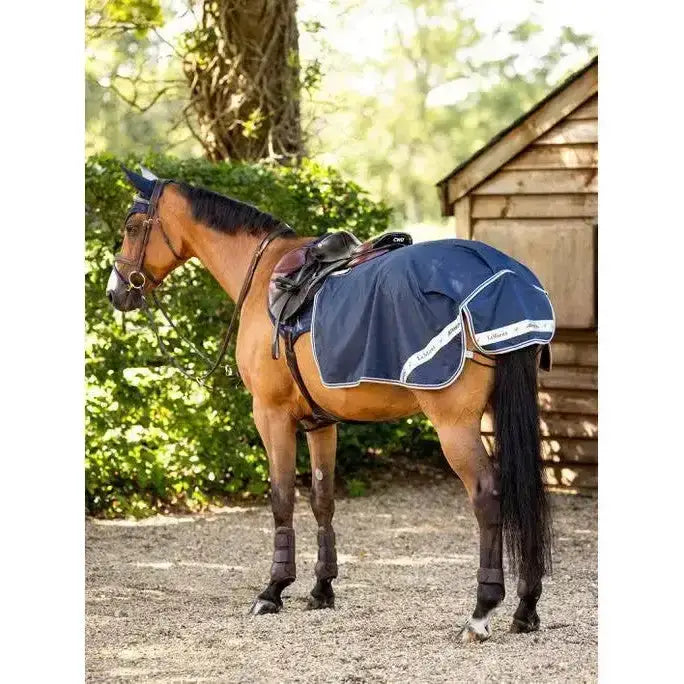 Navy lemieux waterproof exercise quarter sheet with cosy fleece lining and white trim on chestnut horse with saddle