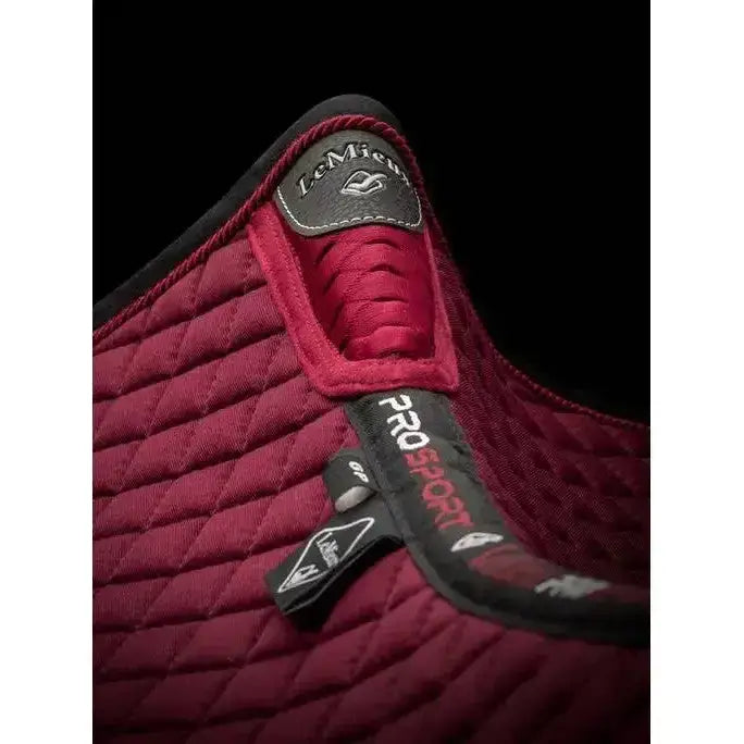 Maroon quilted lemieux wither relief jump pad with black trim and branded tags for comfortable riding