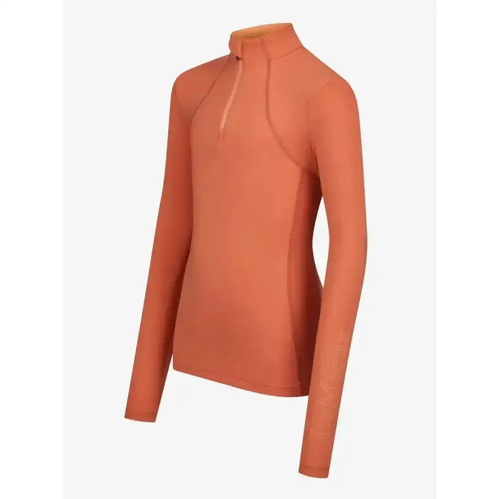 A sleek lemieux young rider base layer apricot with long sleeves, high collar, and subtle zipper detail