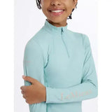 Light blue long-sleeved lemieux young rider base layer aqua with high collar quarter zip and subtle branding on sleeve