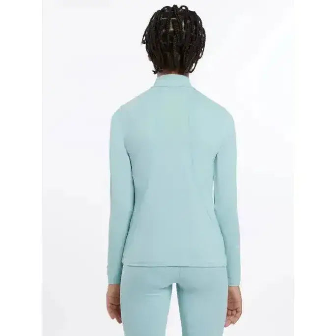 A woman wearing a lemieux young rider base layer aqua set in light blue perfect for young riders