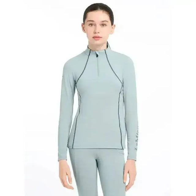 Light blue lemieux young rider base layer glacier with black seams and a half-zip collar for active use