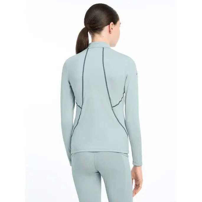 Light blue long-sleeved Lemieux Young Rider Base Layer Glacier on a model’s back