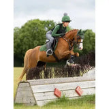 A brown horse wearing green lemieux young rider base layer hunter gear with helmet and bridle for riding