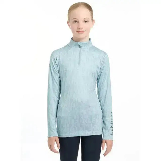 Light blue lemieux young rider casey base layer glacier performance top with long sleeves and quarter zip collar