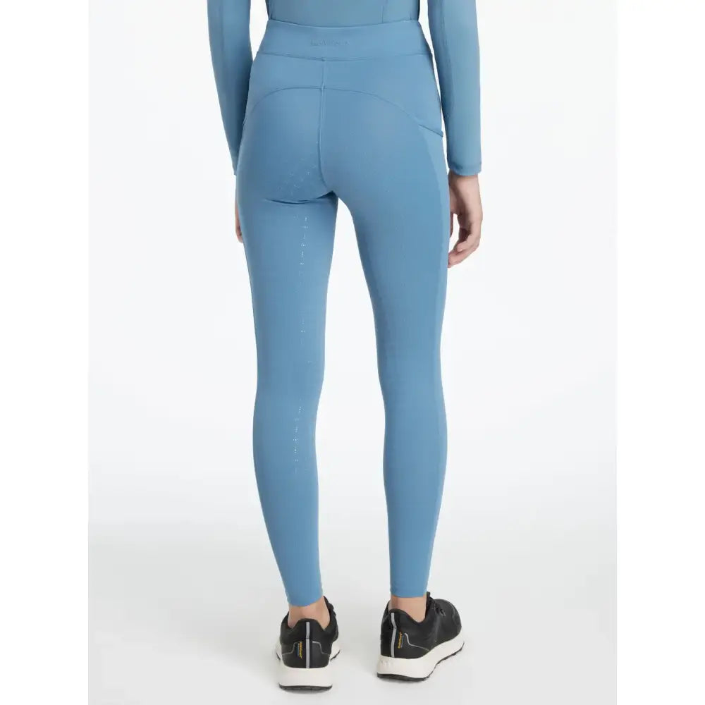 Light blue high-waisted leggings with side pockets and smooth fabric from lemieux young rider classique ice blue layer