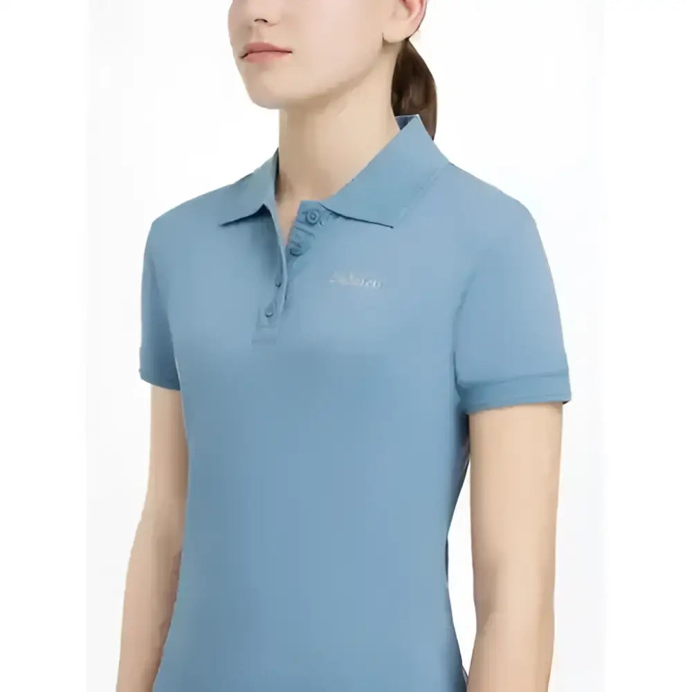 A light blue lemieux young rider classique polo shirt with short sleeves and a subtle embroidered logo on the chest
