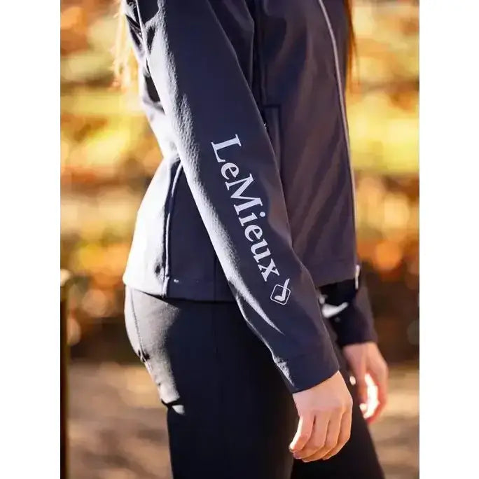 Dark navy blue lemieux young rider elite soft shell jacket sleeve with white embroidered branding on soft material