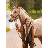 Pale horse with braided mane beside a child in Lemieux Young Rider Eloise Reversible Gilet